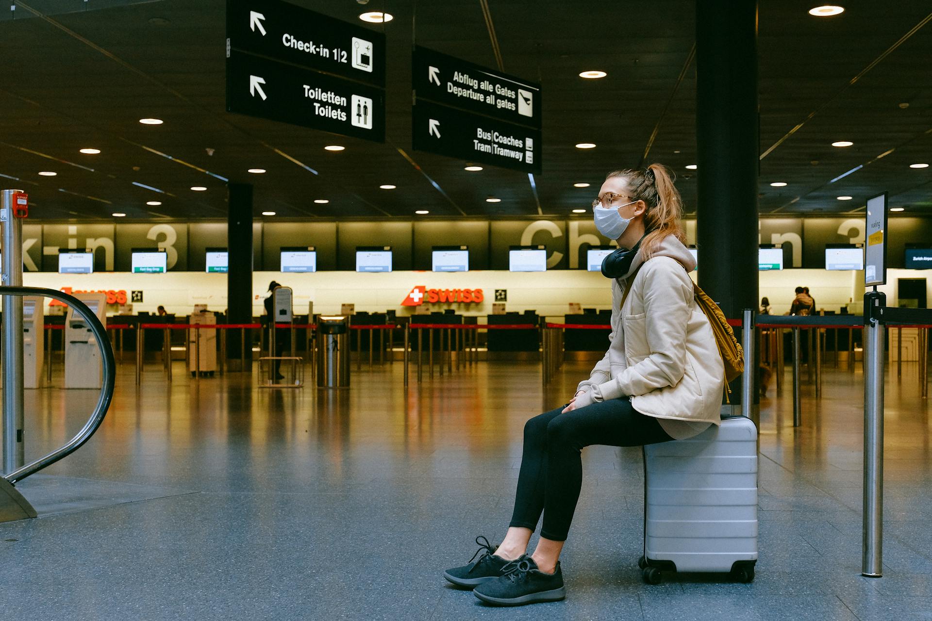 woman sitting on her luggage